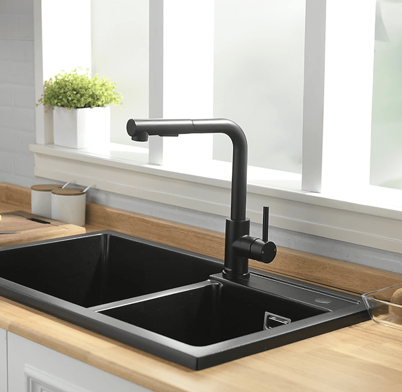Testina nera EYN BG1708 in uso su un rubinetto da cucina sopra un lavello doppio